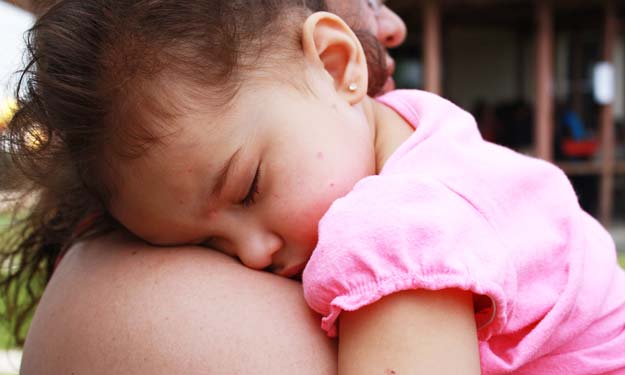 Child resting on parents shoulder